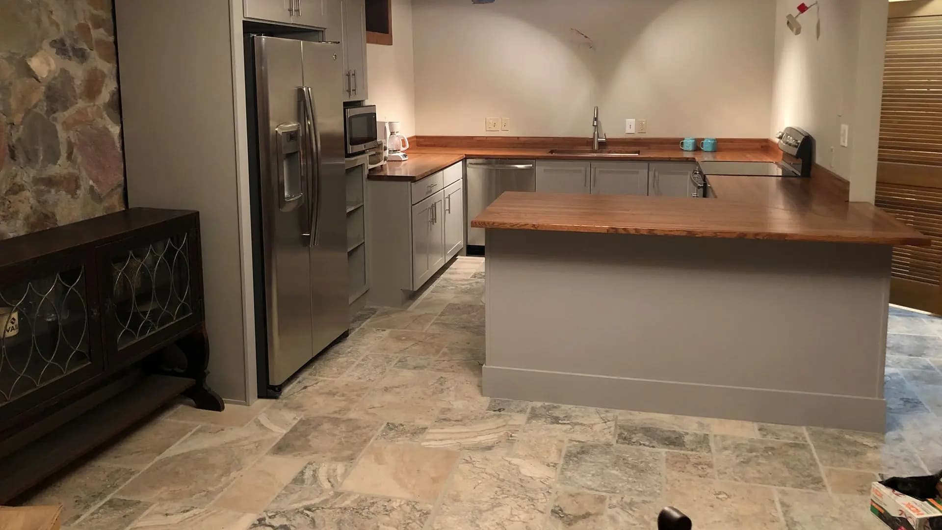 a kitchen with a stainless steel refrigerator and a wood counter