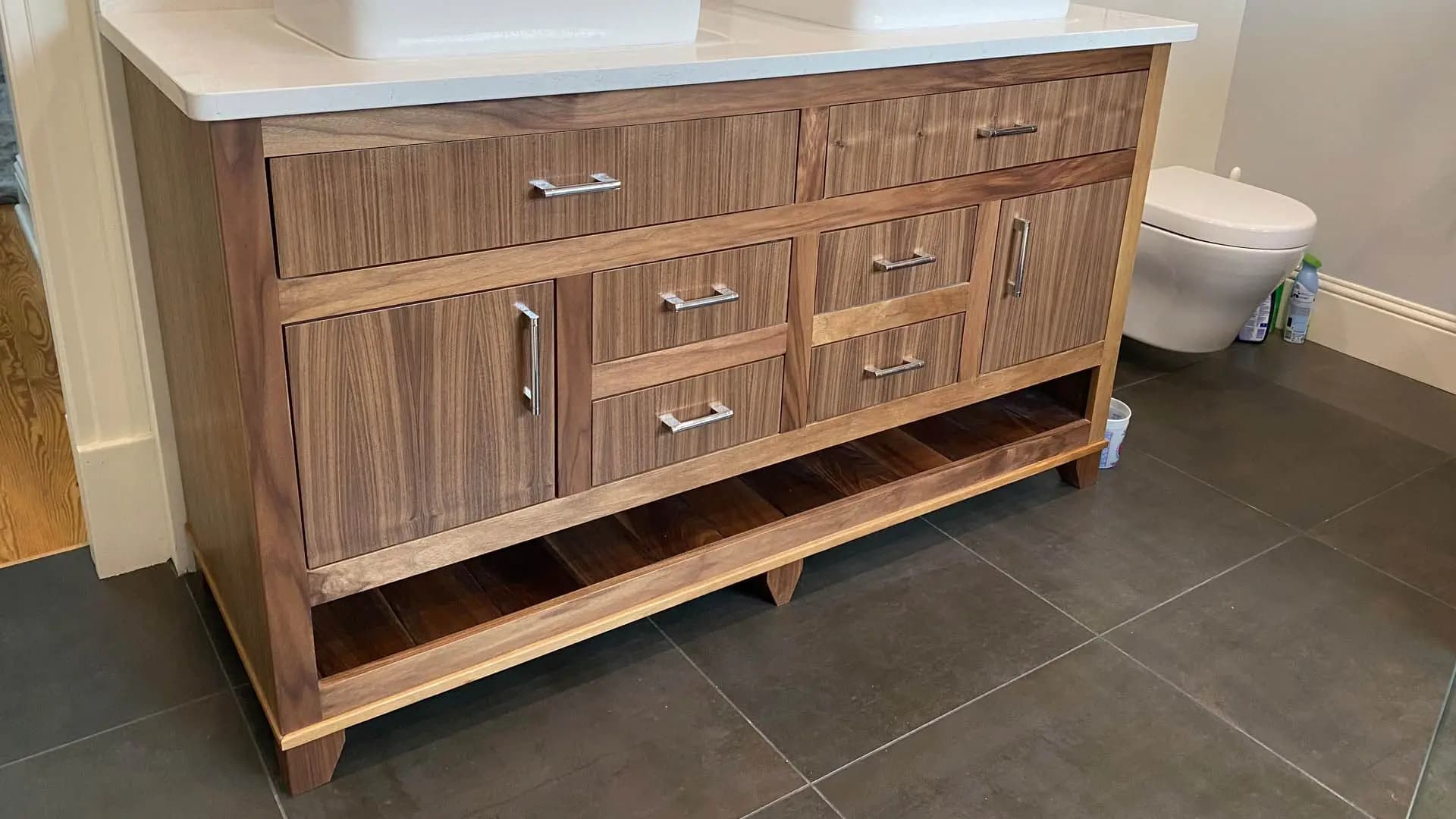 a wooden bathroom vanity with a white sink