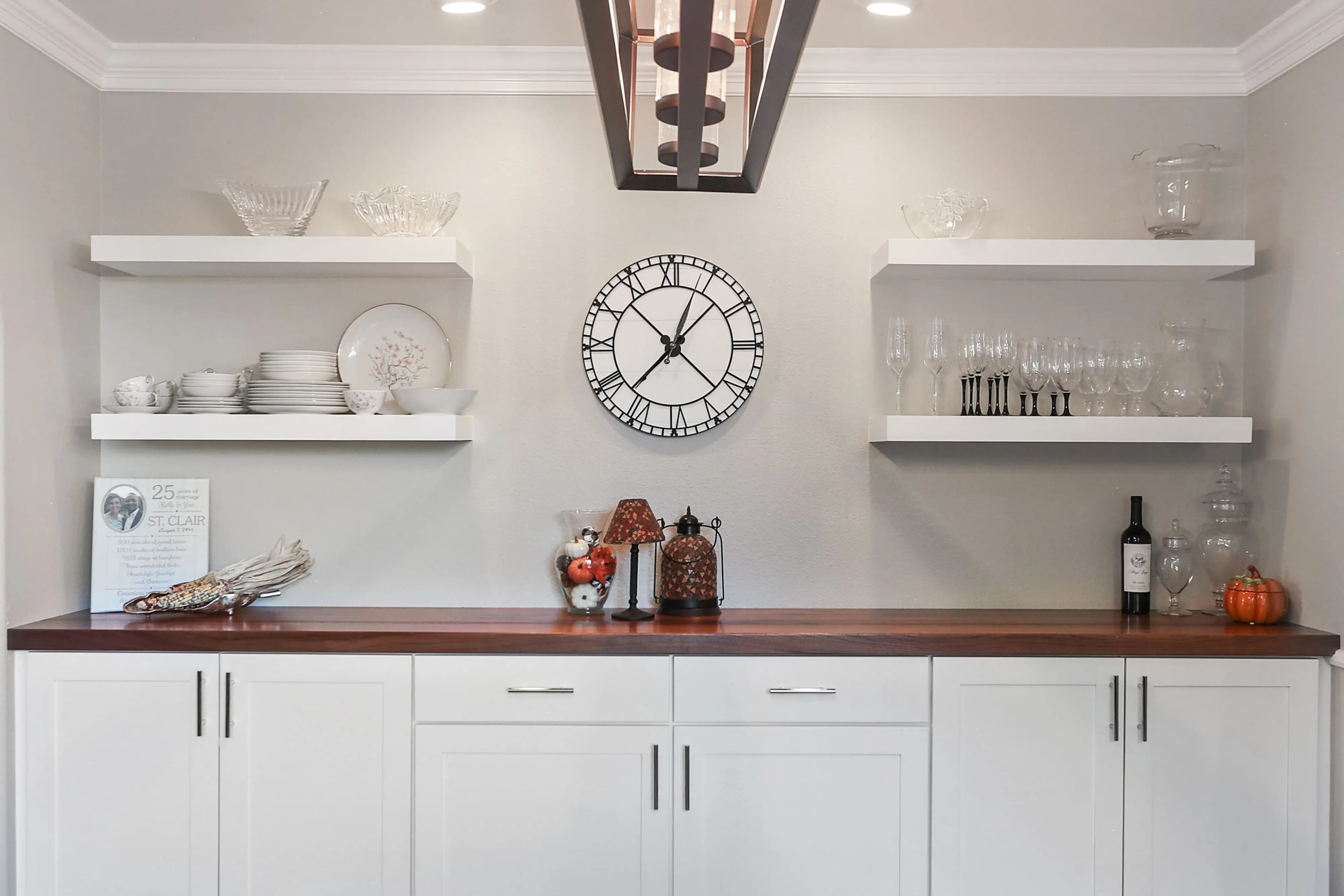 a shelf with a clock and chinawares