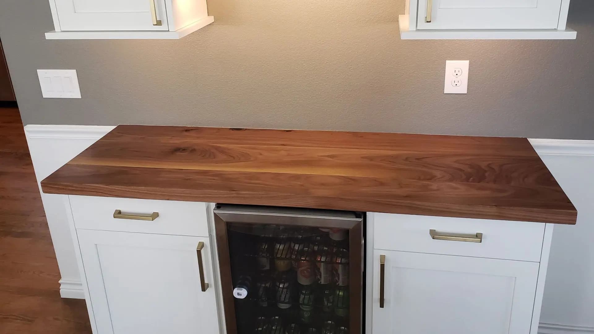 a wooden counter top with a beverage fridge